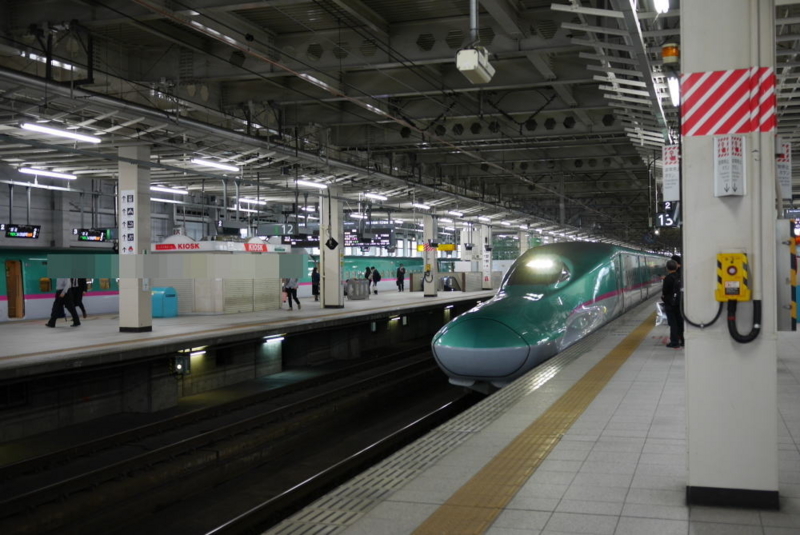 ホーム内でゆっくり走行する新幹線